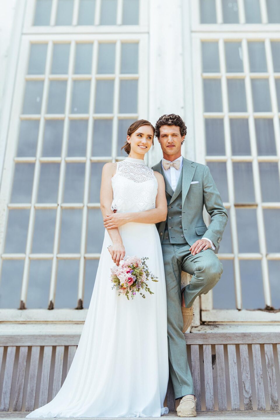 Braut mit Stehkragen Brautkleid neben Bräutigam im hellblauen Hochzeitsanzug